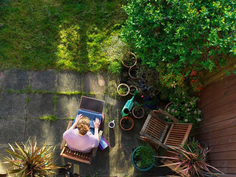 Woman working remotely on her laptop in her garden