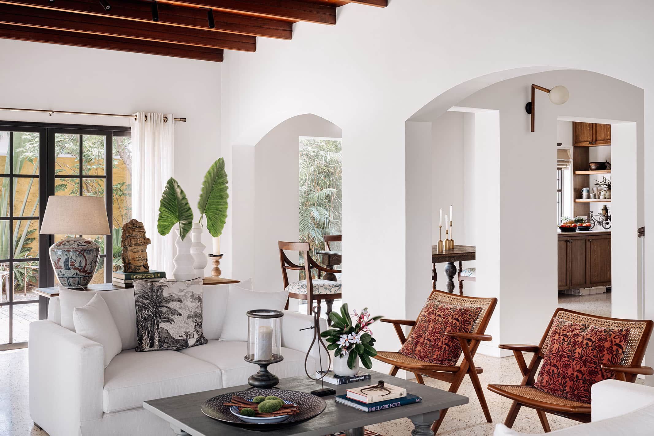 The living room in the family villa designed with white walls and dark wooden furniture by Ceebros Designworks