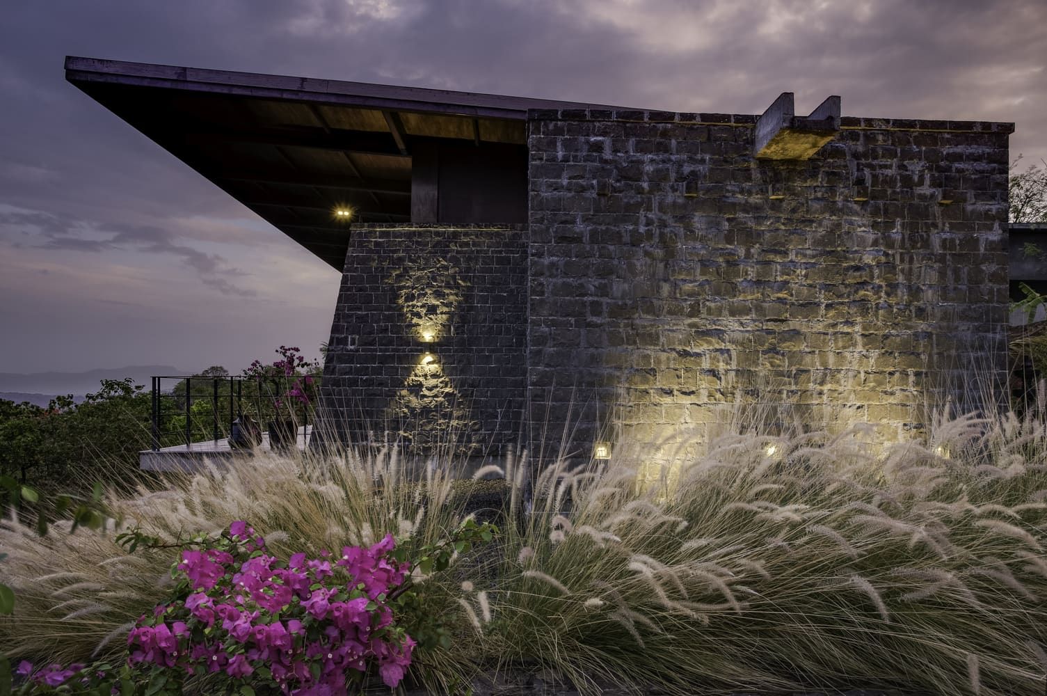 stone facade and plants of Hermitage Retreat in twilight