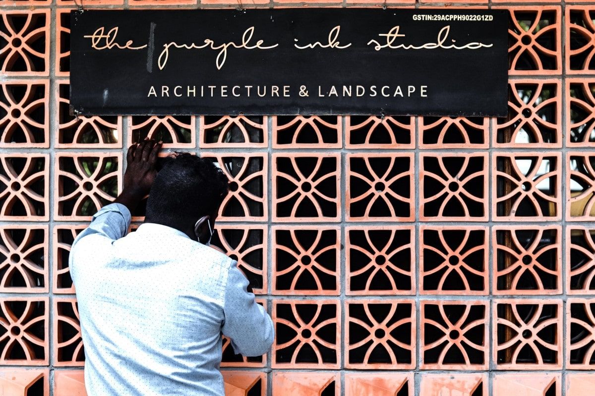 A man on the phone in front of the entry gate of Purple Ink Studio