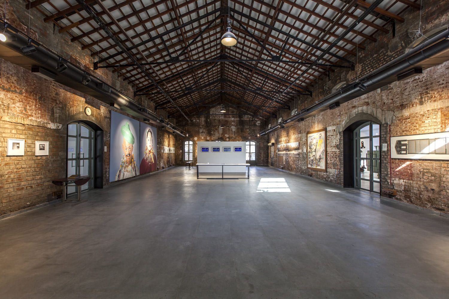 A spacious exhibition hall with a wooden truss roof 