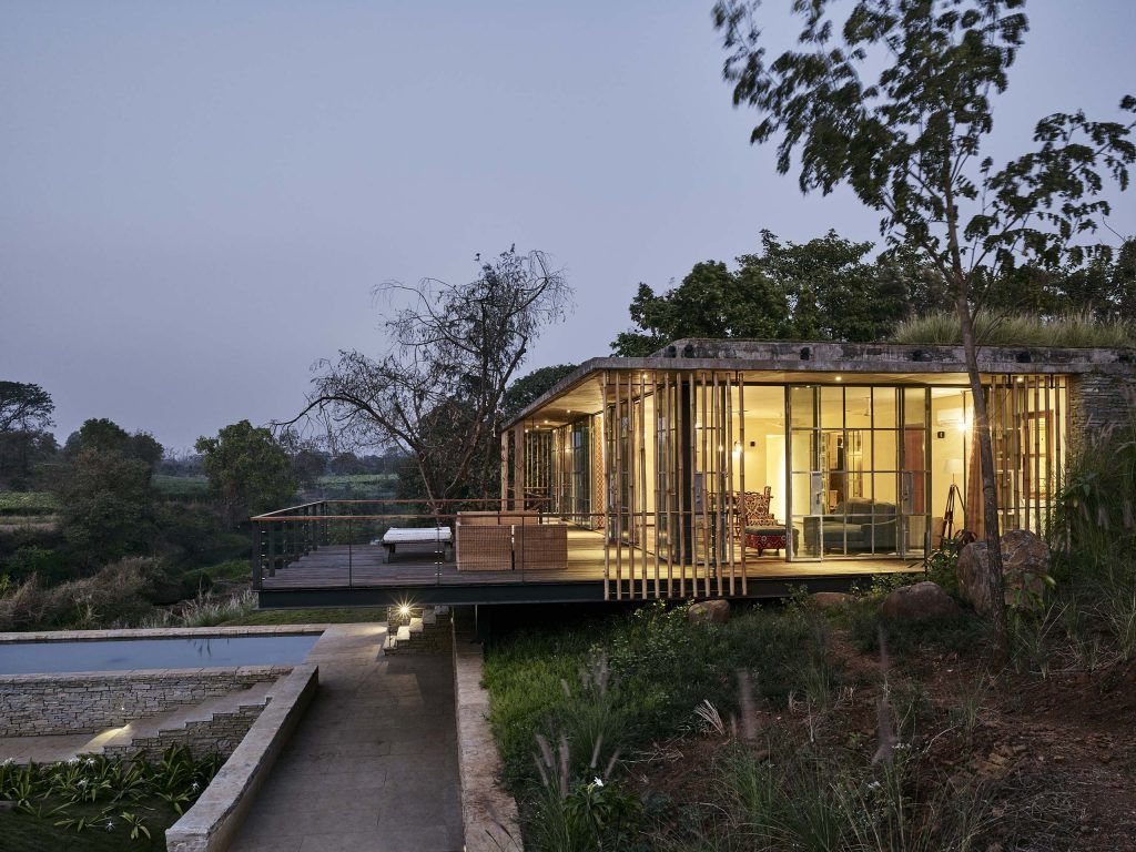 The side facade of Riparian House seen with its bamboo pole screen and the pool in front