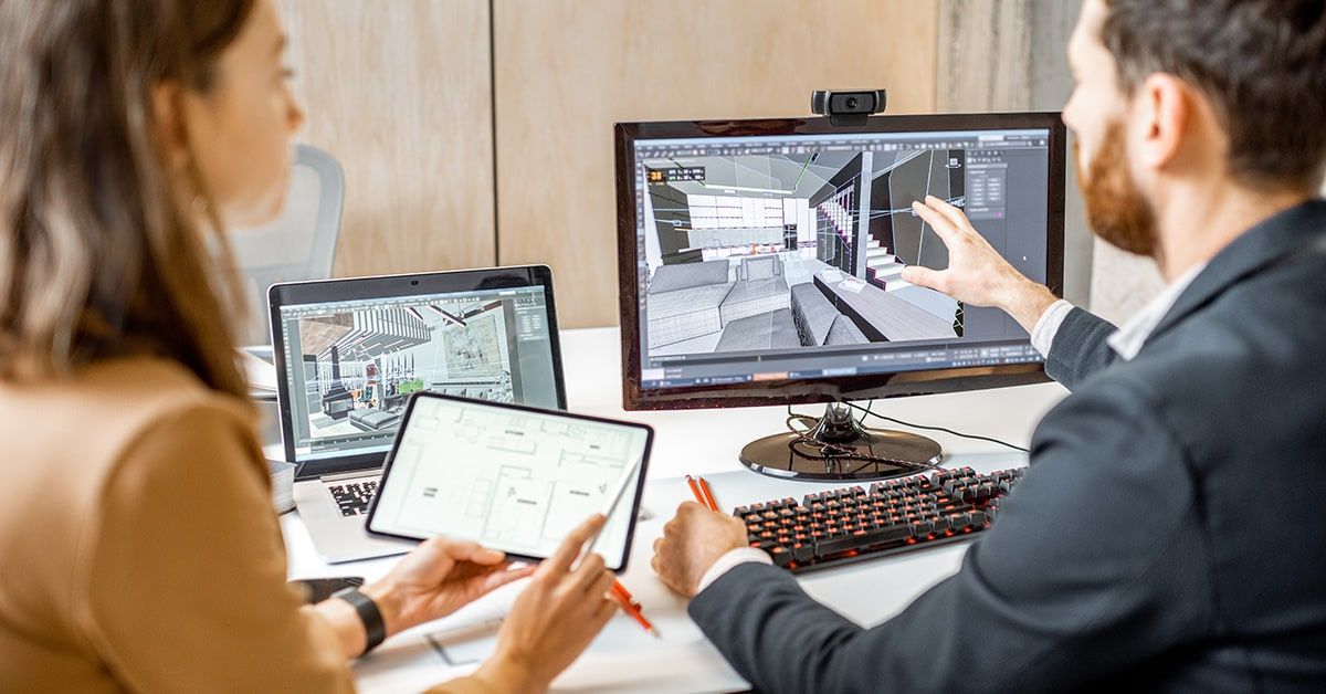 Two BIM professionals working with a 3D model on multiple screens
