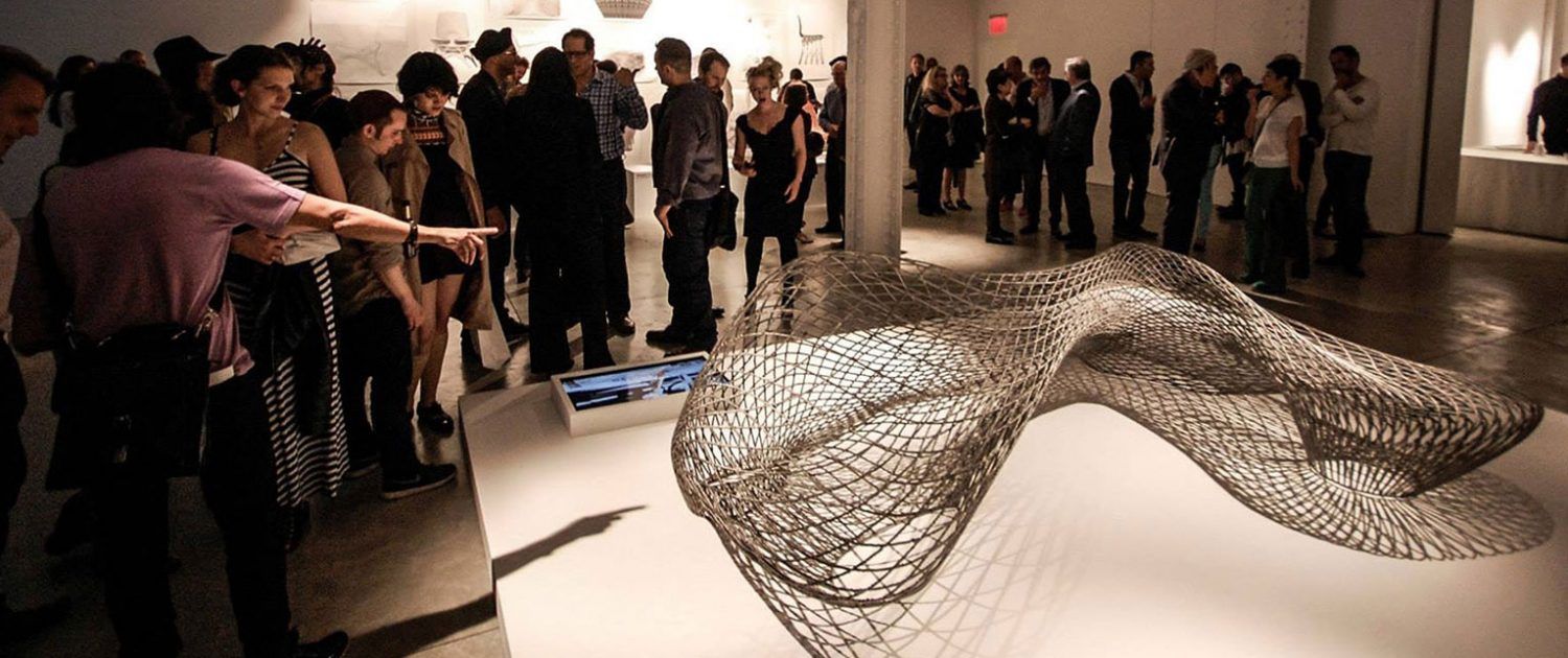 Dragon bench being viewed by a crowd of visitors in a gallery