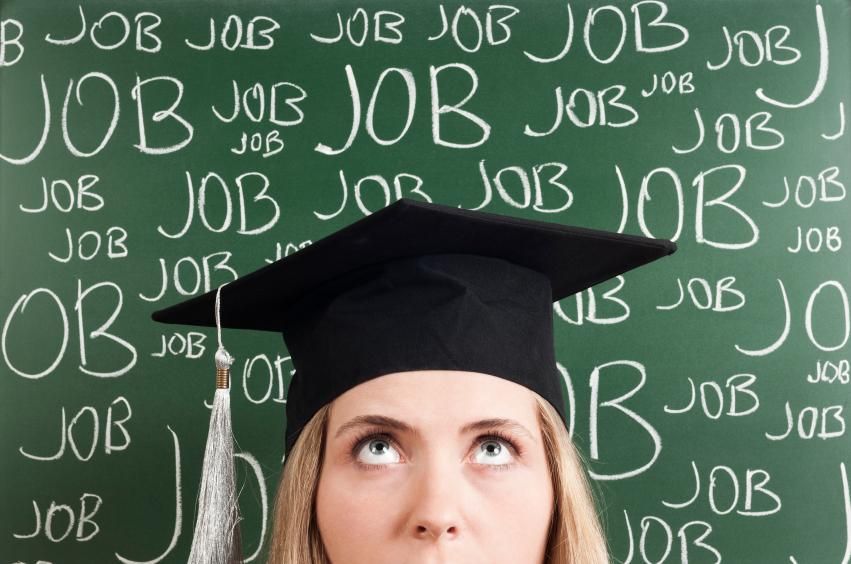 a woman wearing a graduation hat against a board with JOB written on it