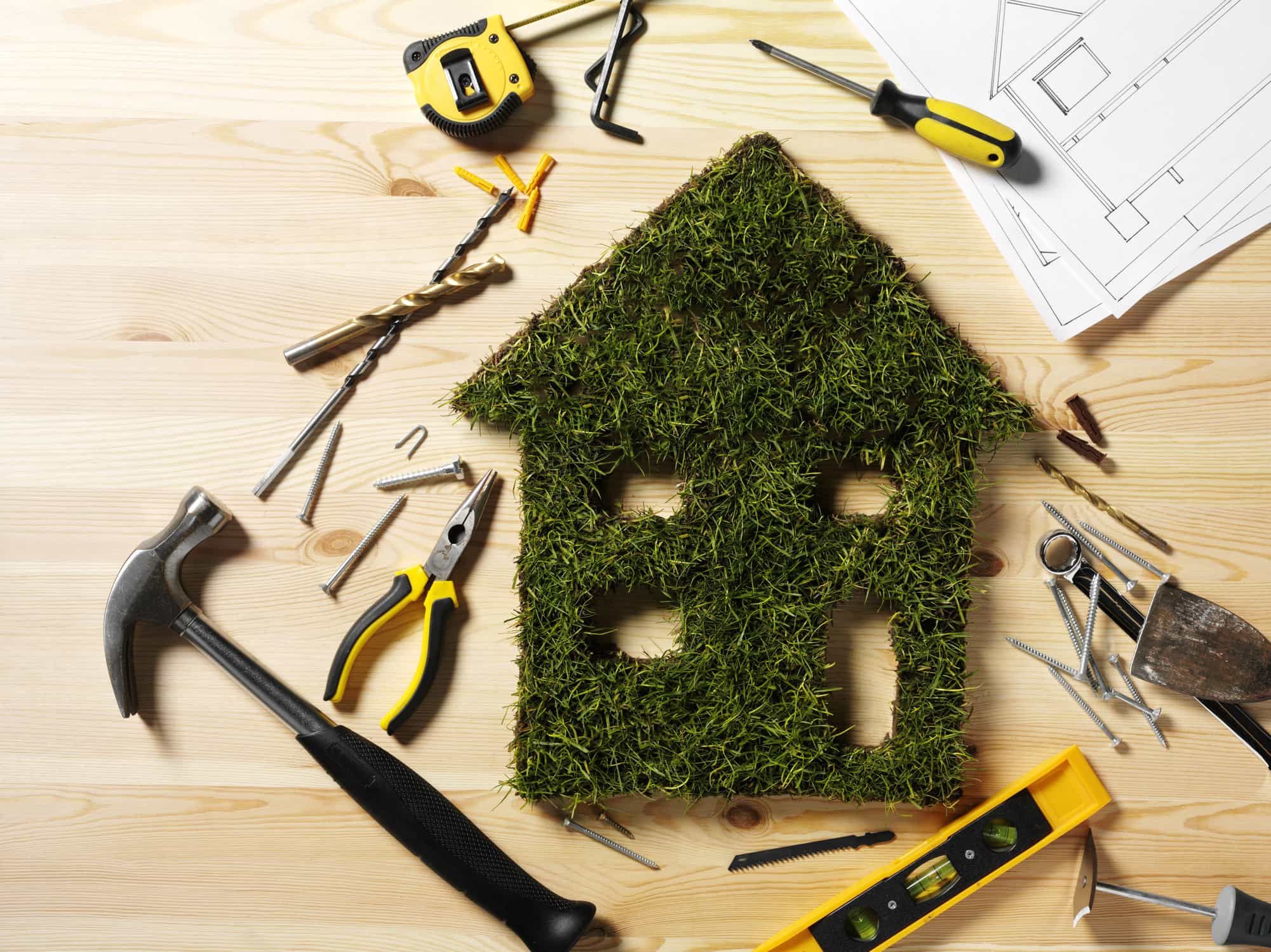 Image of house-shaped patch of grass surrounded by various building tools
