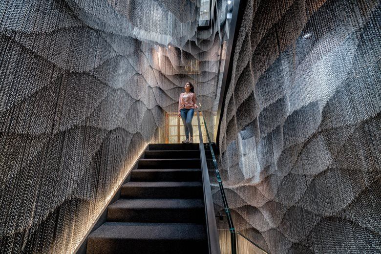 A girl walking down the stairs between two parametric walls