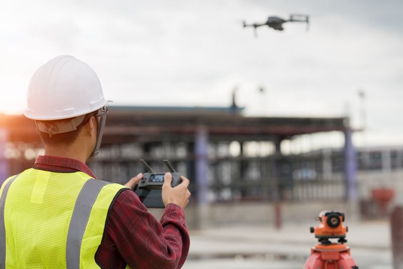 A construction worker using a drone at the construction site
