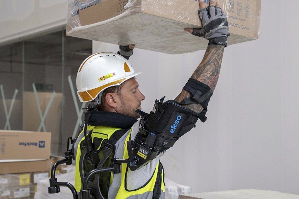 A construction worker using an exoskeleton to lift heavy objects on site